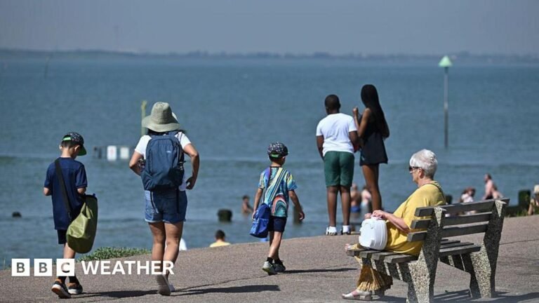 Are ‘heat spikes’ becoming more common? A beach prominade with one lady sitting on a bench while others are walking and looking out to sea