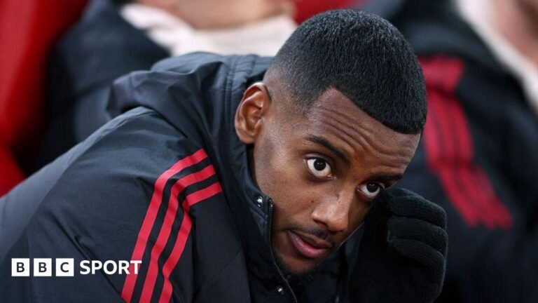 Alexander Isak: The saga which damaged two seasons Alexander Isak looks on from the bench in a zip-up dark jacket with red stripes before the Champions League game between Liverpool and PSV Eindhoven at Anfield on 26 November, 2025