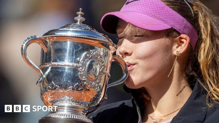 A close-up of Mirra Andreeva's jacket bearing the phrase 'I want to thank myself' while she holds the French Open winners' trophy