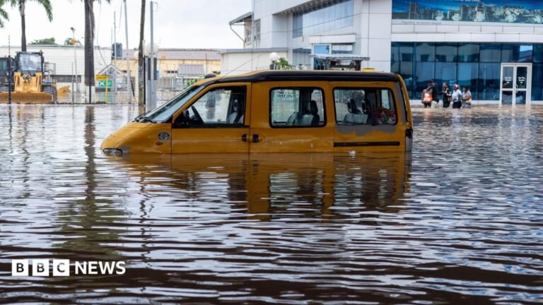 A yellow van half-submerged in floodwater
