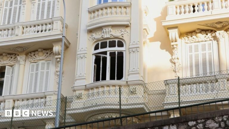 Parcel bomb injures Ukrainian oligarch and family in Monaco – reports The damaged window of a light yellow residential building, which has balconies and ornate carvings.