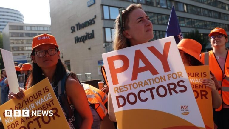 Resident doctors on strike hold placards outside St. Thomas's hospital in London