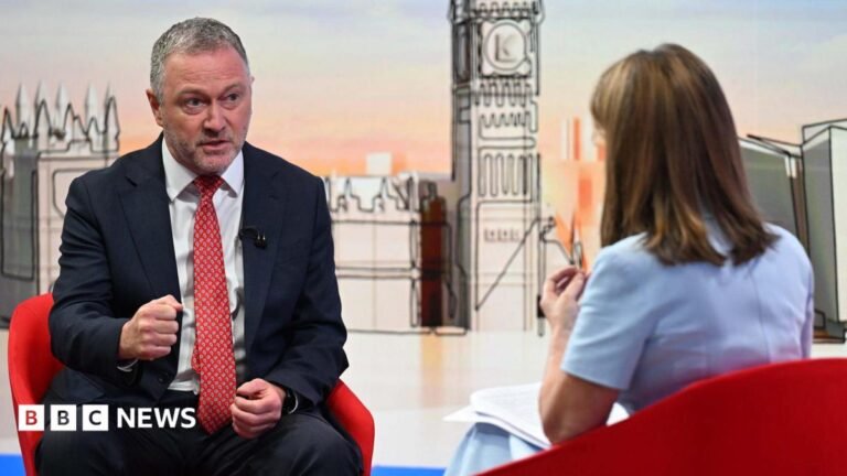 Senior Labour figures say party is united behind Andy Burnham Housing, Communities and Local Government Secretary Steve Reed appearing on the Sunday with Laura Kuenssberg, with presenter Victoria Derbyshire standing in. The pair sit on red bucket chairs. Reed wears a black suit with a white shirt and a red tie. Derbyshire is wearing a pastel blue dress with short sleeves. She has shoulder length, dark blonde hair.