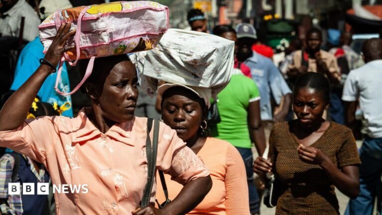 Supreme Court allows Trump to end protected status for Haitian and Syrian migrants Three Haitian women carry bags on their heads as they walk down a crowded street. Two women wear orange blouses and one wears a brown t-shirt.