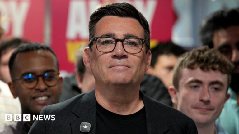 The economic challenges facing the next prime minister Andy Burnham wearing a black jacket with a black t-shirt talking to an audience with supporters gathered behind him