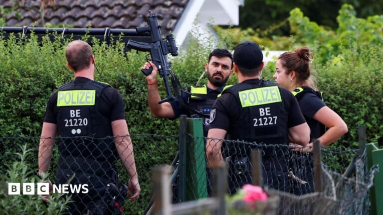 Berlin Pride attack suspect shot and killed during police operation Four police officers are pictured, with one officers holding a gun up