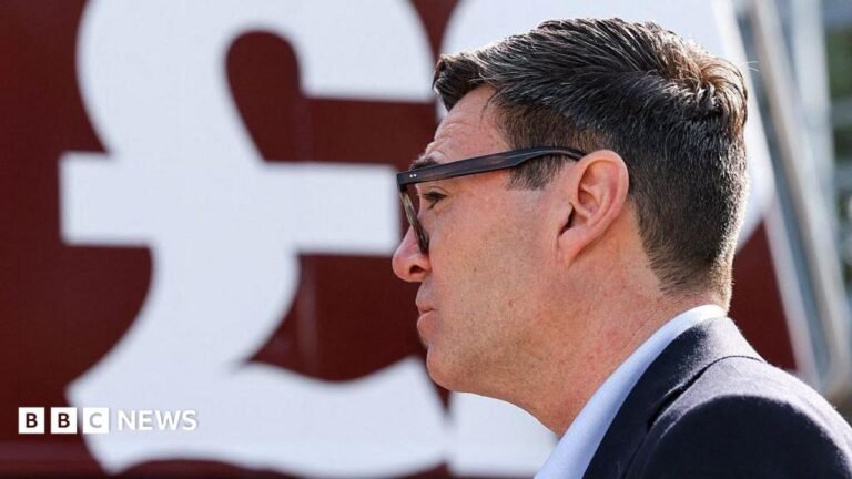 Burnham has no scope to increase borrowing, think tank warns Side profile of Andy Burnham with a large £ sign behind him.