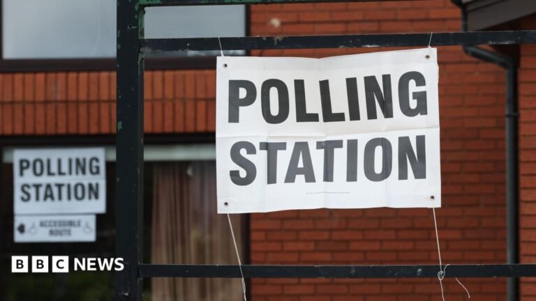 Greater Manchester mayoral election polling stations open A red-brick building with a paper sign tied to black railings. The sign reads: 'POLLING STATION'.