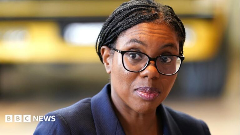 Kemi Badenoch tells PM not to raise taxes to fund social care A picture of Kemi Badenoch from the shoulders up. She is wearing a dark blue suit jacket and black-rimmed glasses. Her hair, which is in braids, is tied back. She is looking to the left and the background is blurred.