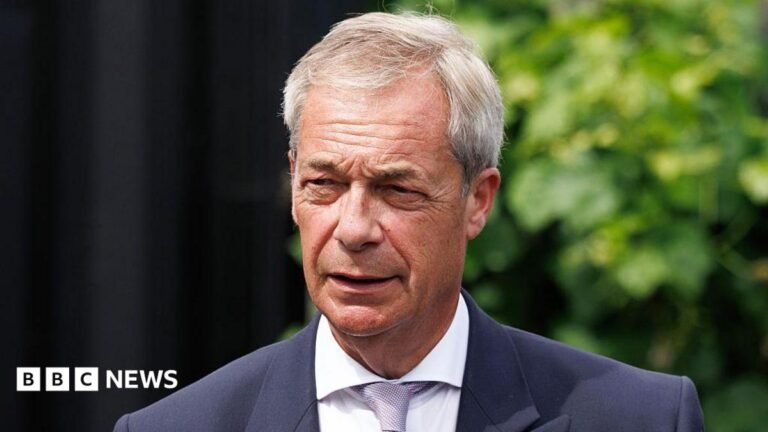 Man arrested over threatening to shoot Farage in social media post A young woman looks down at her mobile phone.
