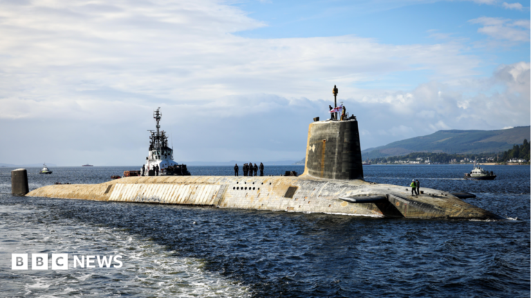 Nuclear submarine investment will protect Britain and boost jobs, PM says A shot of a Vanguard submarine half submerged in the water.