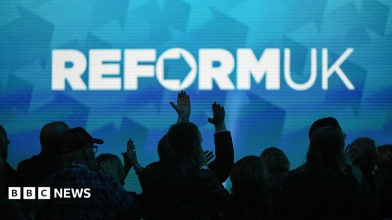 Police investigate Reform donations, the Times reports A Reform UK slogan projected on a wall with crowds pictured below in the dark.