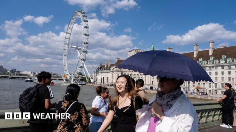 UK weather: Parts of country to get break in heatwave but dry spell to continue People walk on a bridge over the Thames in London using an umbrella for shade with strong sunshine overhead.