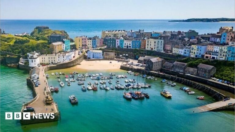 Welsh holiday home tax rules could be eased after backlash An aerial shot of Tenby harbour in Pembrokeshire, showing docked boats and colourful houses on the seafront.