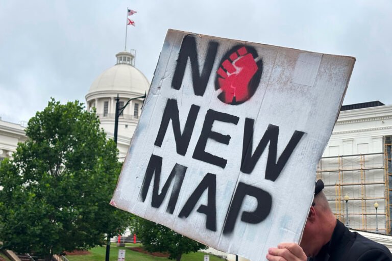 A demonstrator holds up a sign outside the Alabama Statehouse in Montgomery, Alabama, on May 7, 2026.