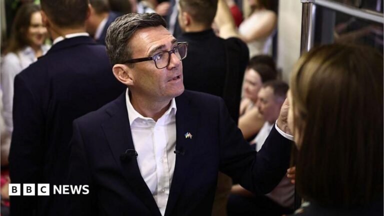 Andy Burnham reacts as he stands in a metro carriage among passengers during the journey between the metro stations Zoloti Vorota and Lukanivska on August 24, 2026 in Kyiv, Ukraine.