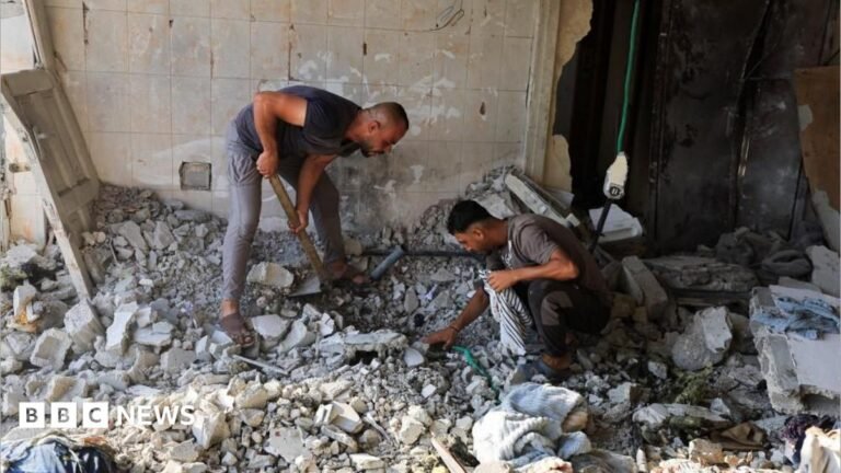 At least eight killed in Gaza after Hamas agree disarmament deal A mother and son pose for a selfie. They are both smiling with the tops of their heads touching. They are standing on a viewpoint, with a canopy of trees and an ocean view far below them.