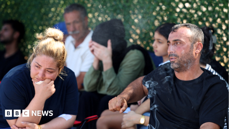 Couple’s children missing as ferry capsizes off northern Cyprus A man smiles as he holds up a phone through which the US president is addressing the audience