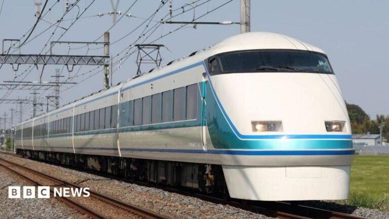 A train travelling on tracks across a field
