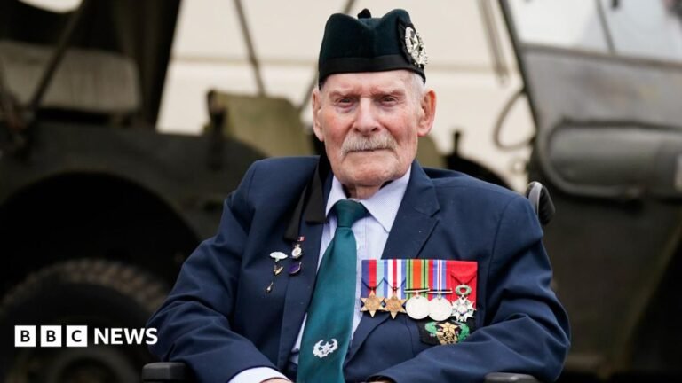 Frinton Normandy veteran who lied about age to enlist dies Donald Turrell is sitting in a wheelchair in front of a military vehicle. He is wearing a black army hat and a suit. On the left side of his jacket is a row of medals from World War Two.