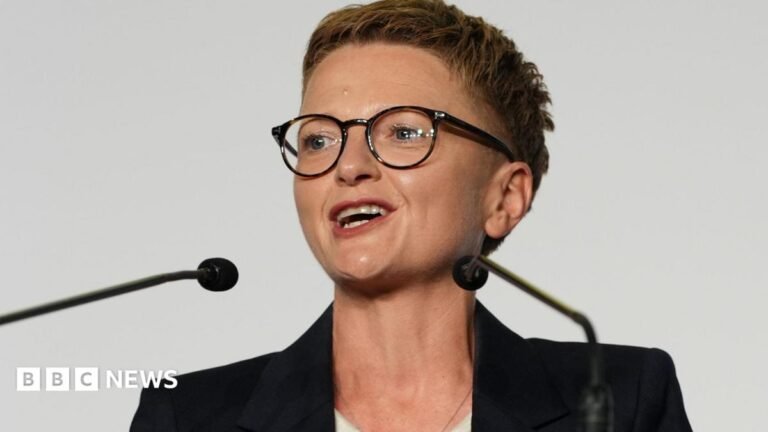 Labour’s Bev Craig elected new mayor of Greater Manchester Bev Craig has short spiky red hair, dark glasses and wears a dark jacket with white roll-neck top.