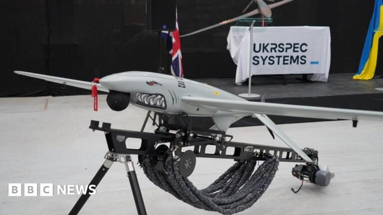 MP calls for transparency over Mildenhall drone factory protection A Ukrspecsystems drone with a shark face and design on its nose propped up on a black metal stand. In the background there is a white banner which reads Ukrspecsystems, and a Ukraine flag draped next to it.