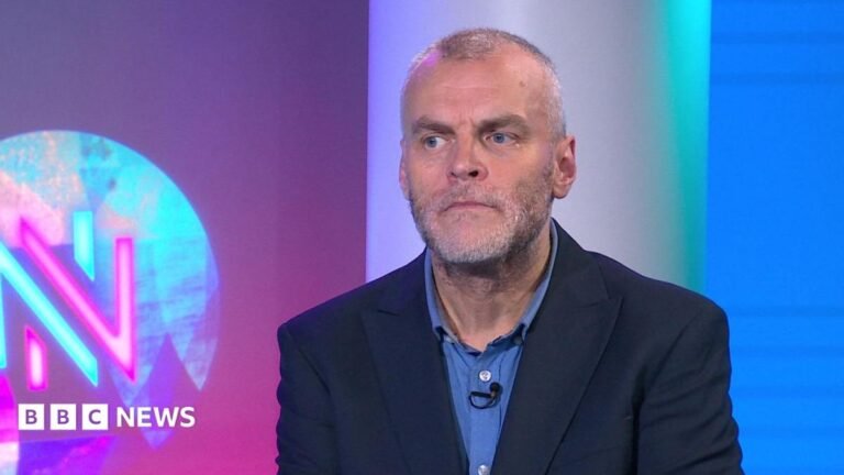 Reform suspends Tory defector Tim Montgomerie after criticism of senior figures Tim Montgomerie, with short cropped hair and a grey beard, is wearing an open necked shirt and suit jacket. He is in the Newsnight studio