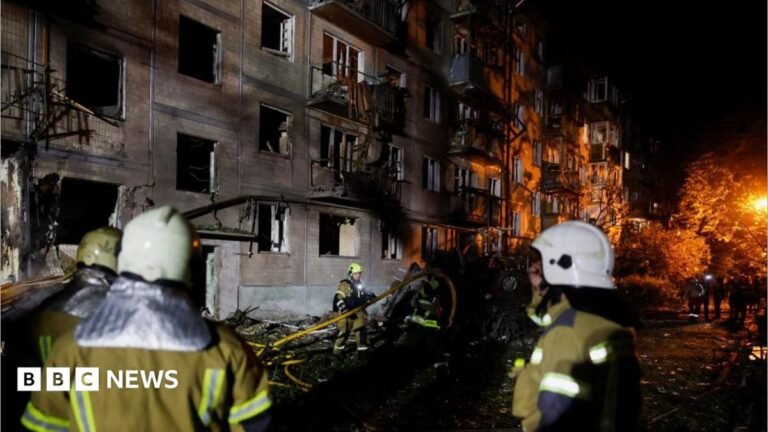 Firefighters work at the site of an apartment building hit by a Russian missile strike in Kyiv