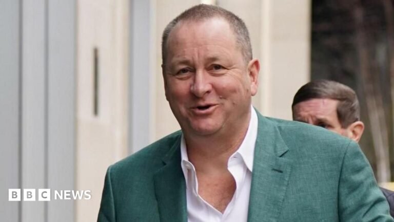 Sports Direct’s Ashley attacks Burnham over ‘populist’ High Street revival plans Businessman Mike Ashley wearing a white shirt, and green suit jacket, smiling at the camera as he walks with a man behind him