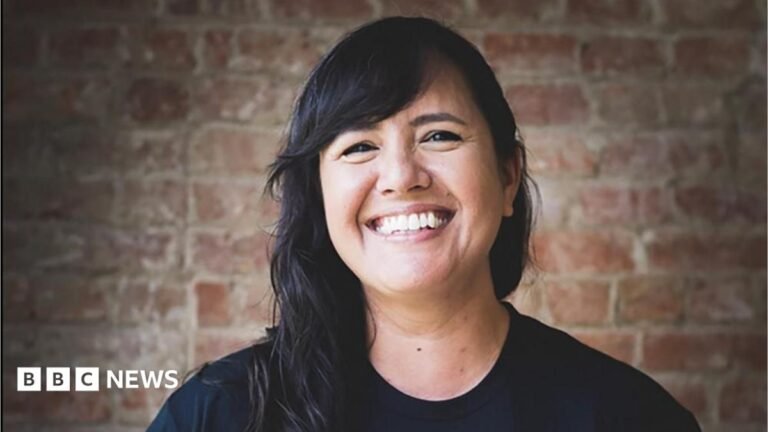 A smiling woman with long black hair.