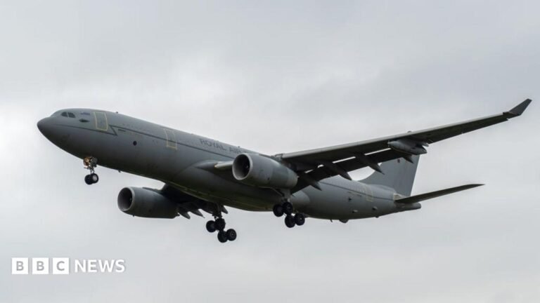 A grey RAF Voyager seen flying through cloudy skies