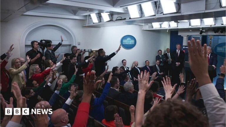 CNN, MS NOW and Politico say reporters denied White House access after Trump banned some media outlets The White House press room full of reporters with their hands raised