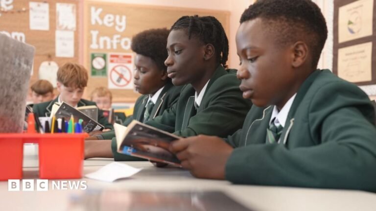 England up in reading, maths and science rankings as Scotland and Wales dip Students in green school uniforms sit at desks reading books during a classroom lesson. Pencil pots and study materials are visible on the tables, with a noticeboard and classroom displays in the background.