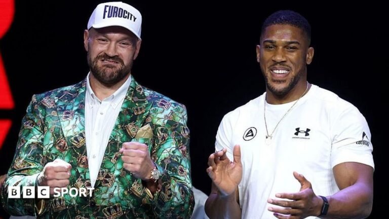 Fury vs Joshua: Heavyweights trade jokes at launch event Tyson Fury holds up his fists and Anthony Joshua holds up his hands and smiles