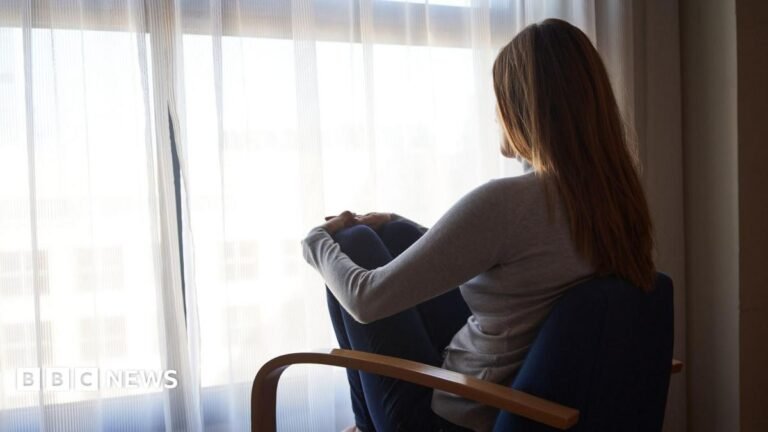Grooming gangs inquiry expanded to Birmingham and Wales A woman sits with her back to the camera on a chair facing a curtained window.