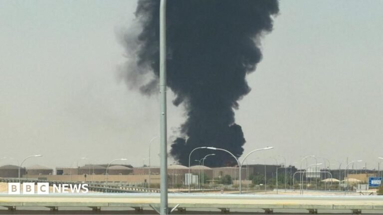 Houthis claim attack on Riyadh after fire near airport Houthi fighters raise weapons as they stand in front of the tail fin of a crashed Saudi F-15 jet