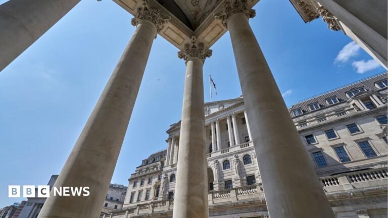 Interest rates hold expected but Bank of England facing tough choices A woman uses a cash machine on the street on a sunny spring day. She holds a credit card in her hand and is pressing buttons on the machine with her other hand.