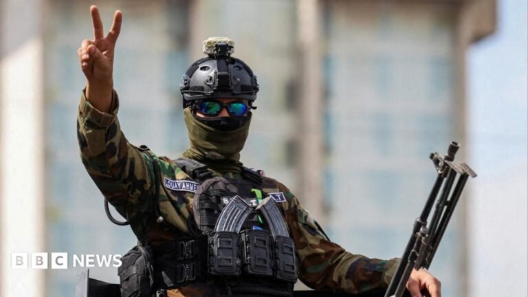 A member of the Iraqi security forces gestures as he travels in a convoy through Baghdad, Iraq (30 September 2026)