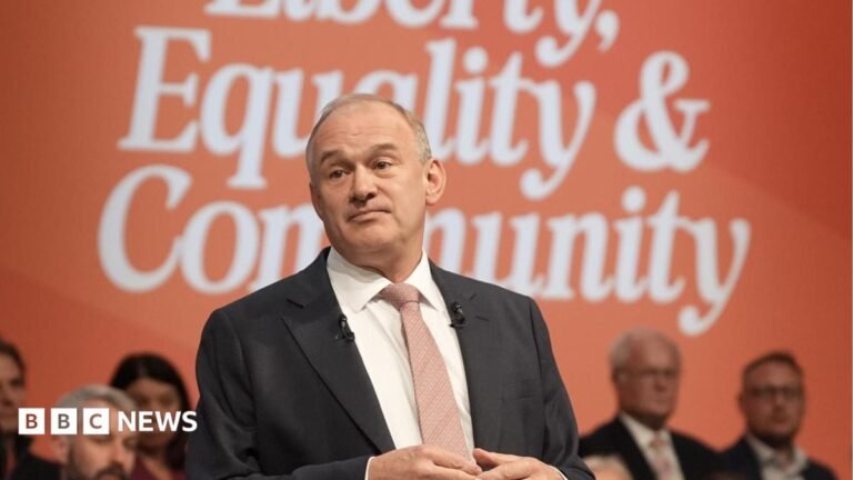 Lib Dems leave conference buoyed by Davey’s message Sir Ed Davey at the Liberal Democrat party conference. He is pictured against a blue and red background, and he is gesturing with his hands as he makes his speech.