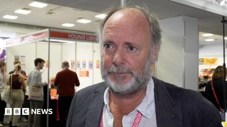 Lib Dems sleepwalking to irrelevance under Davey, says council leader Julian Brazil, a bearded man in an open necked shirt and Lib Dem lanyard, speaks to the BBC in the exhibition hall at the Lib Dem conference
