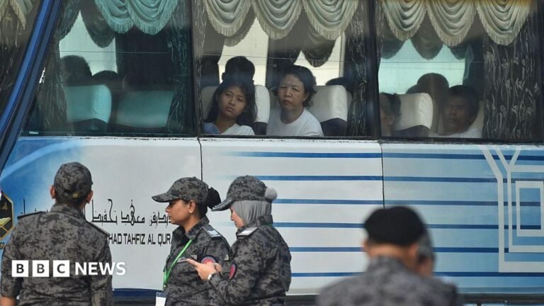 Malaysia begins controversial repatriation of asylum seekers to Myanmar People look out the window of a bus while personnel in military uniform stand in the foreground