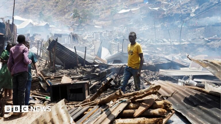 More than 20 children feared dead in DR Congo school fire Man in yellow t-shirt stands in piles of rubble and corrugated iron while three other people stand on the left of the picture. The rubble seems to go on for some distance and the air is hazy.