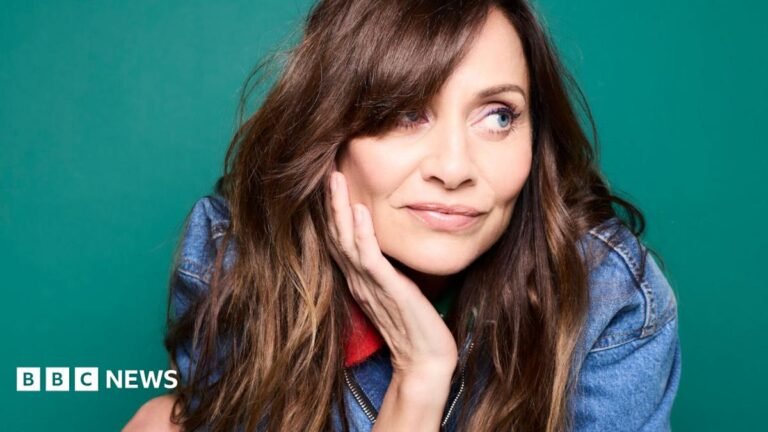 Promotional photograph of Natalie Imbruglia in a denim jacket, with her head resting in her right hand