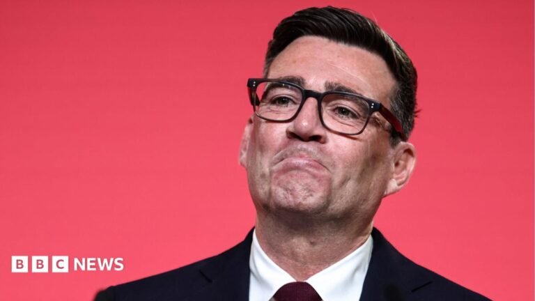 New policies, election speculation: What to expect from Burnham’s first Labour conference as PM Andy Burnham looking pleased as he reacts to becoming Labour leader. He is wearing black rimmed glasses and a dark suit and tie, against a red background.