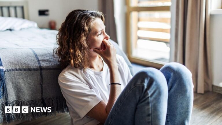 New right to bereavement leave to cover step and half relatives A woman sitting on the floor in her bedroom, looking into the distance.