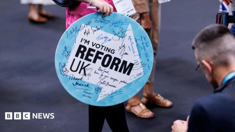 Reform UK winded by donations row as insiders call for shift in approach A woman holding a sign saying I'm Voting Reform UK enters the Reform conference. The sign has autographs on it from Reform politicians.