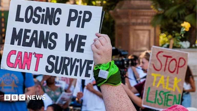 Support for disability benefits ‘remarkably strong’ report finds Protesters holding colourful picket signs during the stop disability benefit cuts rally in Parliament Square in 2025.