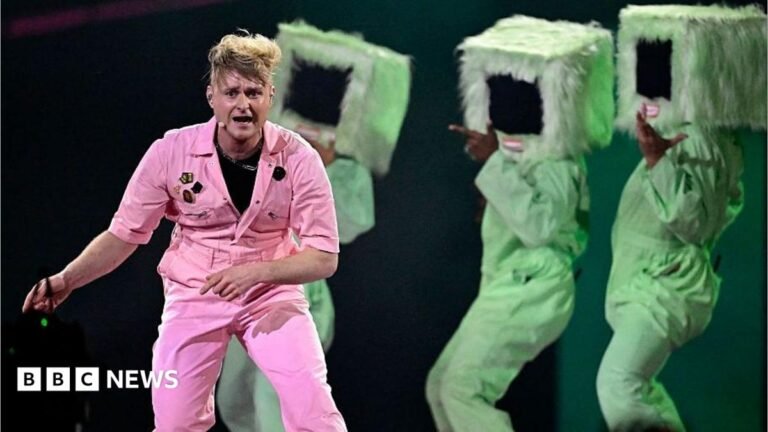 UK’s ‘dismal’ Eurovision song choices to be examined by MPs Earl Spencer walking, wearing a navy suit and a purple tie.
