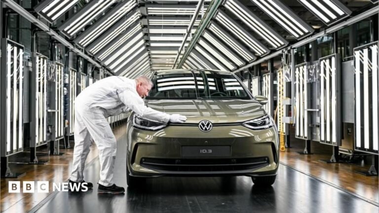 Volkswagen board approves plan to cut another 50,000 jobs A cut of of Anthony Zurcher wearing a suit and tie in front of a red, black, grey and blue graphic background featuring the US Capitol Building