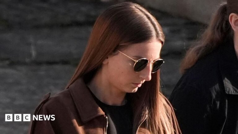Wiltshire teacher sexually abused pupils at multiple schools Bronwen James walking into court wearing a brown jacket over black clothing and sunglasses with died long brown hair